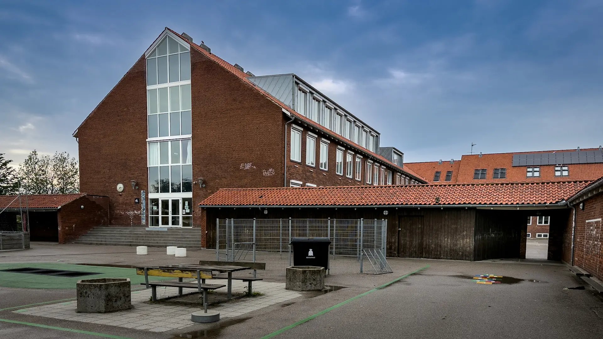 Vælgermøde på skole med politikere og borgere i publikum, hvor debat om skolepolitik og lige vilkår i fokus